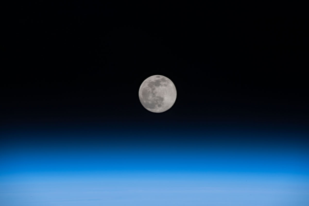 地球の大気から昇りつつある歪んだ満月 アストロピクス