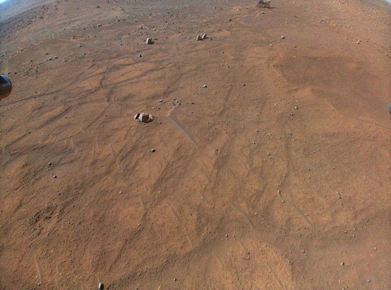54回目の飛行時にインジェニュイティから撮影された画像。画像の撮影時、インジェニュイティの高度は5mでした。画像の上端にパーサヴィアランスが映っています。Image Credit: NASA/JPL-Caltech