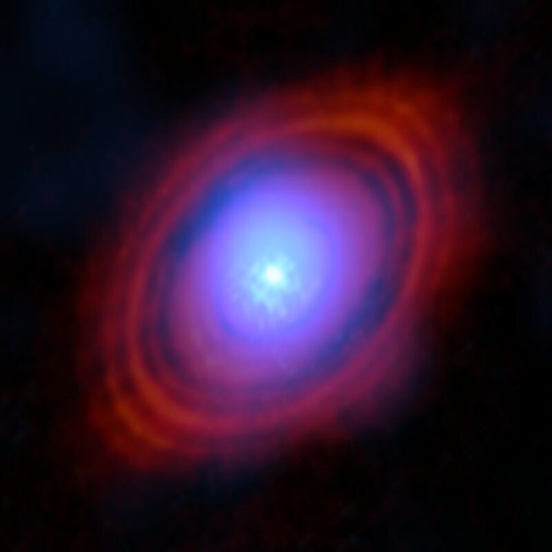 アルマ望遠鏡でとらえた、おうし座HL星の原始惑星系円盤。青く見えているのが新たな観測で得られた水蒸気。赤く見えているのは、アルマ望遠鏡で以前とらえられた塵の分布です。Image Credit: ALMA (ESO/NAOJ/NRAO)/S. Facchini et al.
